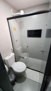 a white bathroom with a toilet and a shower at FLATS CERRADO santa casa in Montes Claros