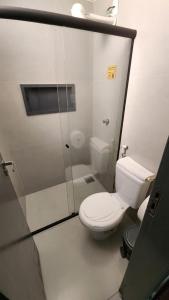 a white bathroom with a toilet and a shower at FLATS CERRADO santa casa in Montes Claros +3 photos