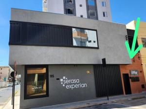 a building with a green arrow pointing to a store at FLATS CERRADO santa casa in Montes Claros