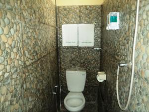Un pequeño baño con inodoro y ducha. en Villa Green House, en Nusa Penida