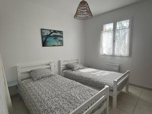 una camera con due letti e una luce a ciondolo di Villa Mireille avec jardin et piscine à Lambesc a Lambesc Altre 21 foto
