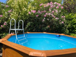 una vasca idromassaggio con una sedia davanti ai fiori di Villa Mireille avec jardin et piscine à Lambesc a Lambesc