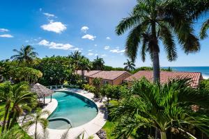 an aerial view of a resort with a swimming pool and palm trees at Beautiful 3 Bedroom Condo With Ocean Views in Tamarindo
