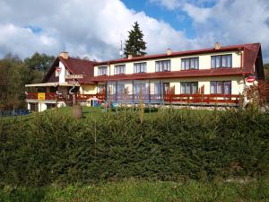 ein Gebäude mit vielen Fenstern auf einem Feld in der Unterkunft Penzion u Kukačků in Horní Planá