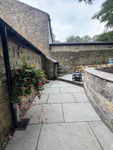 een stenen muur met een terras met bloemen erop bij The Reading Room, Shilbottle in Shilbottle