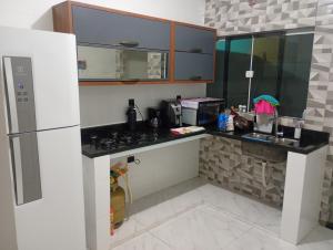 a kitchen with a sink and a refrigerator at Kitnet temporada in Cabo Frio +2 photos