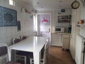 a kitchen with a white table and a microwave at Ferienhaus an der Nieste in Niestetal