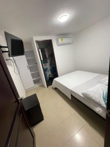 a bedroom with a bed and a flat screen tv at La Noelia in Cali