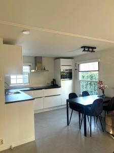 a kitchen with a table and chairs in a room at Bosparel met ruime tuin en airco! in Oisterwijk