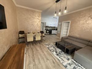 a living room with a couch and a table with chairs at Apartament DVR Baile Felix in Sînmartin