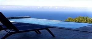 a chair sitting next to a swimming pool at Villa Mahot in Petite Île