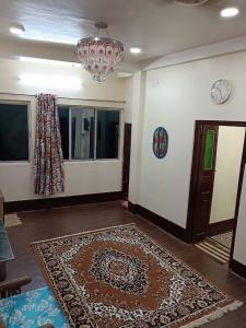 Habitación con alfombra en el suelo y lámpara de araña en Family Rooms, en Calcuta