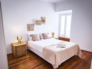 a white bedroom with a large bed and a window at T3 Apartment - Cascais Historic Center - 100m from Beach in Cascais