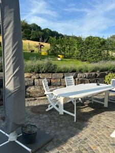 a white table and two chairs on a patio at Gemütliche Ferienwohnung direkt am Wald in Arnsberg