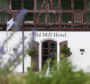 Old Mill Hotel في كلايبيدا: لافتة فندق طاحونة قديمة على جانب المبنى
