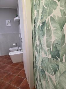 a bathroom with a toilet and a leafy wall at Cà Fiamma 3 in Casale Monferrato +29 photos