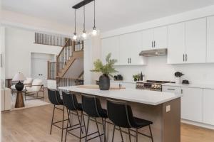 a kitchen with white cabinets and a table with chairs at Luxury 4BR Home with Games Room, BBQ and Sunroom in Lake of Bays