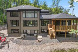 a large house with a staircase in front of it at Luxury 4BR Home with Games Room, BBQ and Sunroom in Lake of Bays