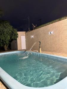 a large swimming pool with a water fountain at Casa Paraíso em Família - Praia Grande/SP in Praia Grande