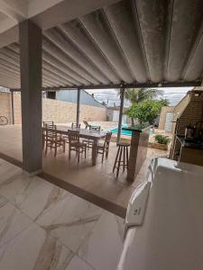 a patio with a table and chairs and a pool at Casa Paraíso em Família - Praia Grande/SP in Praia Grande +30 photos