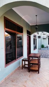 a table and bench sitting outside of a building at Villa Modern Two Bedroom Vacation home in Mbezi Beach in Dar es Salaam