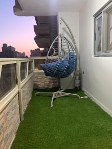 a room with green grass and a hammock on a balcony at المهندسين in Cairo +3 photos