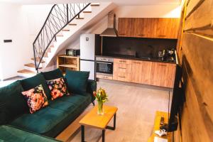 a living room with a green couch and a kitchen at Wellness Chata Cep in Cep