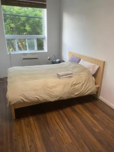 a bed in a bedroom with a wooden floor at Room in a Luxury Loft near Jean-Talon Market in Montréal