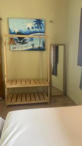 a bedroom with a bed and a mirror and a painting at Casa em Praia de Flecheiras in Trairi