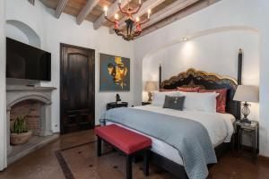 una camera con un grande letto e uno sgabello rosso di Casa Elegante, 3BR Modern Retreat in Centro San Miguel de Allende a San Miguel de Allende