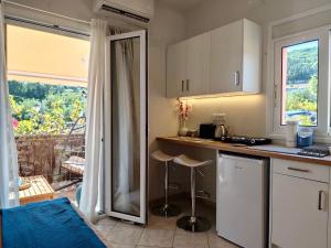 a kitchen with a counter and a view of a balcony at Reginas studios & apartments - Bougainvillea Suite in Fiskardho