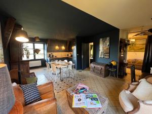 a living room with a couch and a table at Cottage du collectionneur in Saint-Laurent-du-Mottay