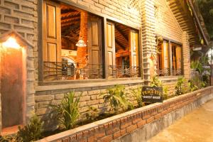 un edificio in mattoni con finestre e un cartello sopra di Peace Eye Guest House a Pokhara