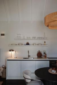 Una cocina con fregadero y una mesa con sillas. en Nubia Suites - Boutique luxury appartments in Otrobanda - UNESCO area, en Willemstad