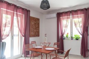 a dining room with red curtains and a table and chairs at Respira Amalfi Coast in Vietri sul Mare