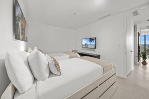 1 dormitorio blanco con 1 cama grande con almohadas blancas en Oceanview Private Home at South Beach-814 1B, en Miami Beach