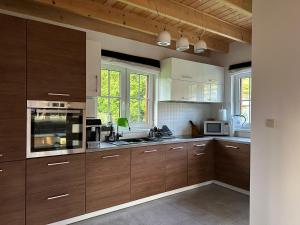 a large kitchen with wooden cabinets and appliances at Anielski Domek in Nieledwia