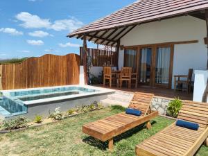 een achtertuin met een zwembad en twee banken bij Primaluna Romantica in La Punta de los Remedios