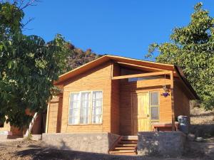 a small wooden house with a front door at Killapura in Los Andes
