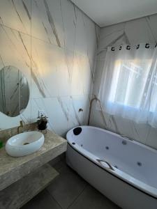a bathroom with a white tub and a sink at Refúgio raiz pousada mineira in Camanducaia +10 photos