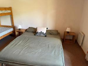 a bed in a room with two tables and two lamps at Les Soleils de la Meije in La Grave
