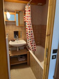 a small bathroom with a sink and a tub at Les Soleils de la Meije in La Grave +23 photos