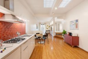 eine Küche und ein Esszimmer mit einer Ziegelwand in der Unterkunft Lungotevere Trastevere Loft in Rom