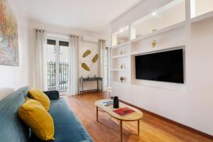 ein Wohnzimmer mit einem blauen Sofa und einem Fernseher in der Unterkunft Lungotevere Trastevere Loft in Rom