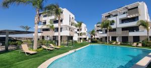 a swimming pool in front of a building with palm trees at Casa Soluna -Santa Rosalia Lake and Life Resort in Torre-Pacheco