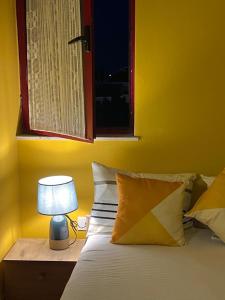 een slaapkamer met een bed met een lamp en een raam bij City Centre Rooms 4R in Shkodër