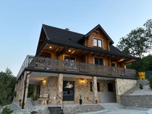 a large wooden house with a balcony at Villa Ligęzówka in Chyrowa