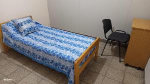 een slaapkamer met een bed, een stoel en een bureau bij Roxi in Don Torcuato +1 foto