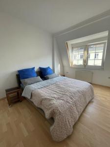 a bedroom with a bed with blue pillows and a window at Entire house with garden - exclusively for your group in Leipzig +22 photos