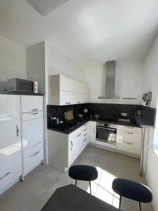 a kitchen with white cabinets and black counter tops at Entire house with garden - exclusively for your group in Leipzig
